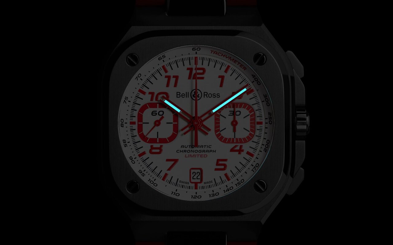 Chronographe Bell and Ross BR-05 Chrono Snow Rocket au cadran blanc, chiffres et compteurs rouges, bracelet caoutchouc rouge, photographié de nuit