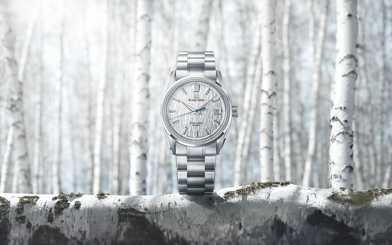 Montre Grand Seiko Evolution 9 Hi-Beat SLGH031 au cadran argenté texturé façon écorce de bouleau et bracelet acier, posée sur un tronc de bouleau dans une forêt enneigée