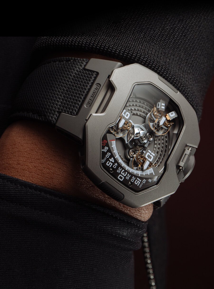 Montre Urwerk UR-120 en titane portée au poignet, dont l'heure est indiquée par un satellite rotatif se déplaçant sur un arc gradué de 60 minutes